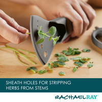 Hands using a tool to strip herbs from stems on a wooden surface.