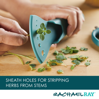 Close-up of hands stripping herbs with a tool on a wooden surface.
