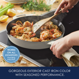 A person cooks shrimp in a cast iron skillet on an induction stovetop.