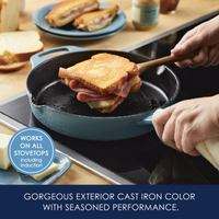 Someone cooking a sandwich in a blue cast iron skillet on a stovetop.