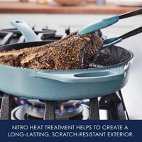 Cooking a seasoned meat in a blue skillet on a stovetop, using tongs.