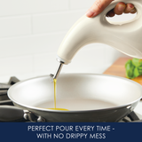 A hand pouring oil into a frying pan with a no-drip dispenser.