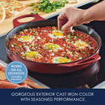Red cast iron pan with eggs and tomato sauce on a stovetop.