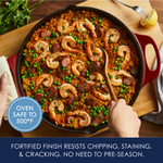 Hands serving shrimp and sausage paella from a skillet; oven-safe to 500°F.