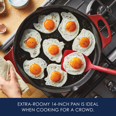 Seven sunny-side-up eggs frying in a large skillet on a stove.