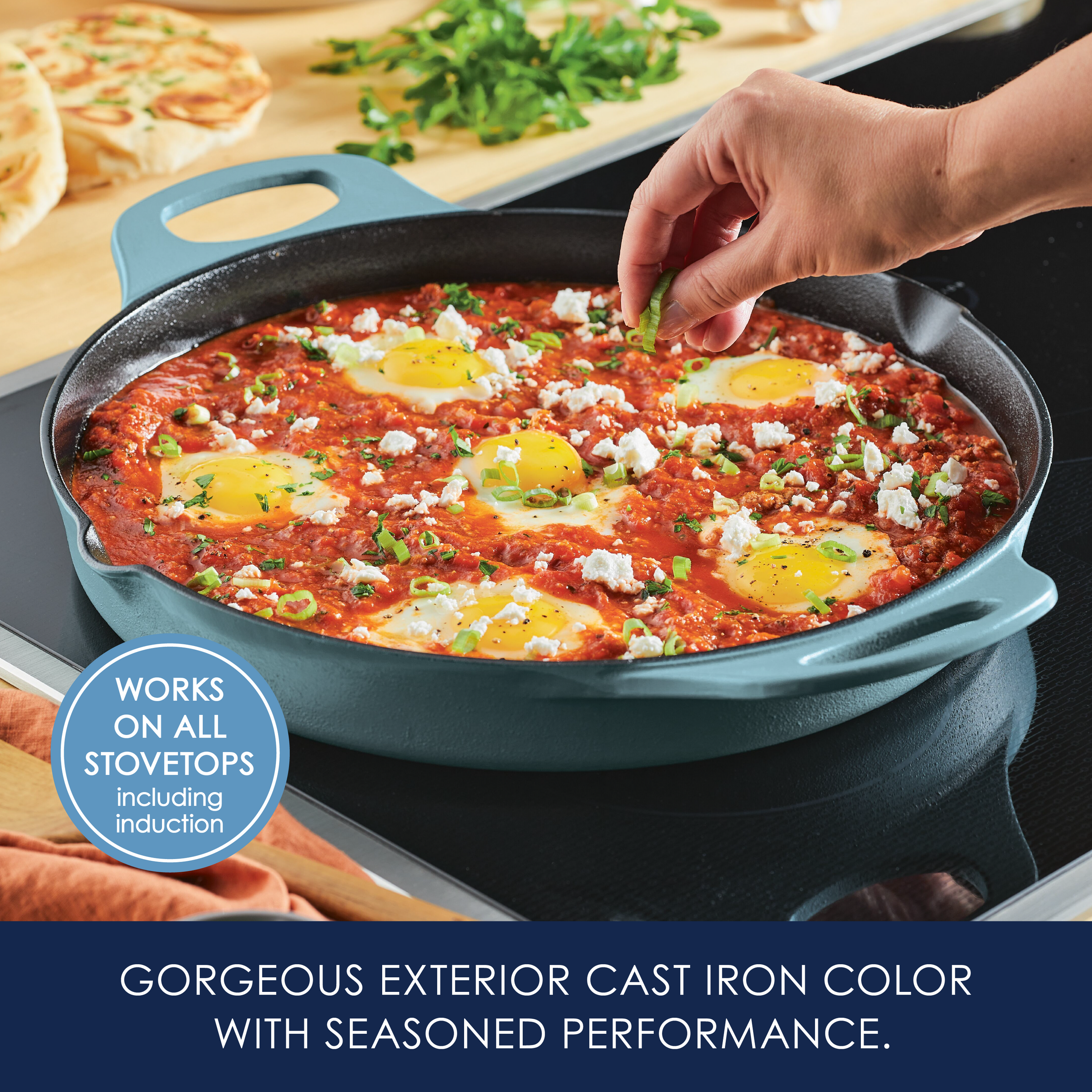 Hands adding garnish to a skillet of shakshuka on a stovetop.