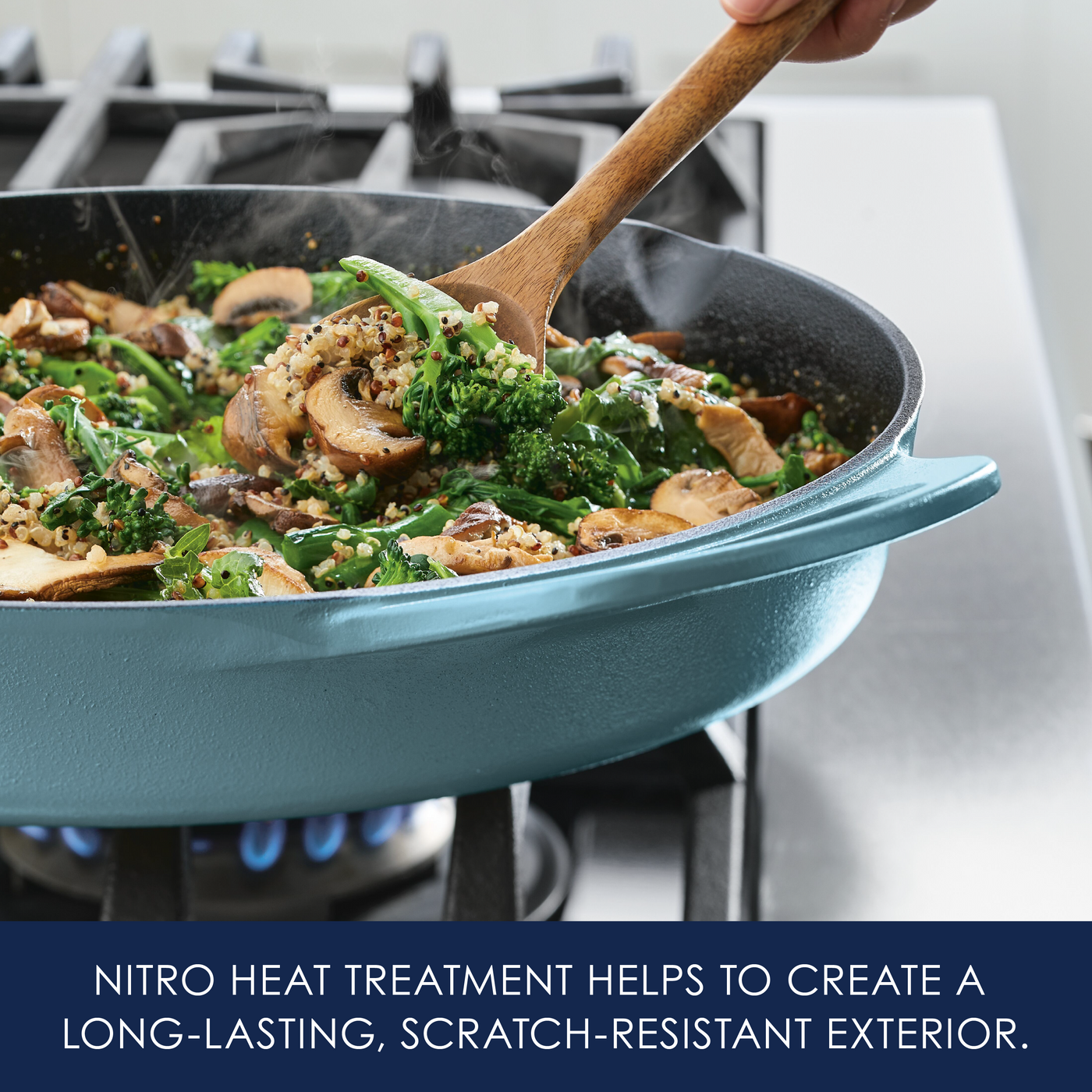 Person stir-frying vegetables in a turquoise frying pan on a stove.