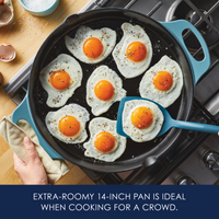 Frying seven eggs in a large pan on a stovetop, with a spatula nearby.