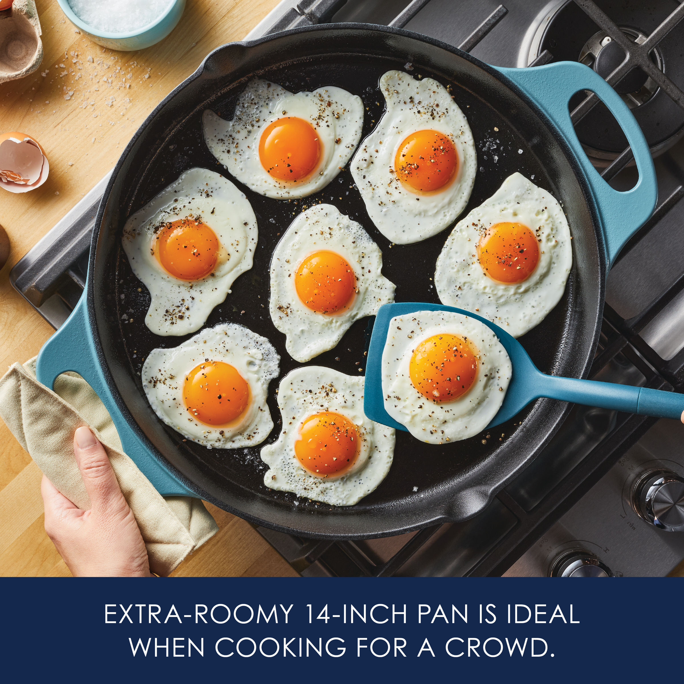 Frying seven eggs in a large pan on a stovetop, with a spatula nearby.