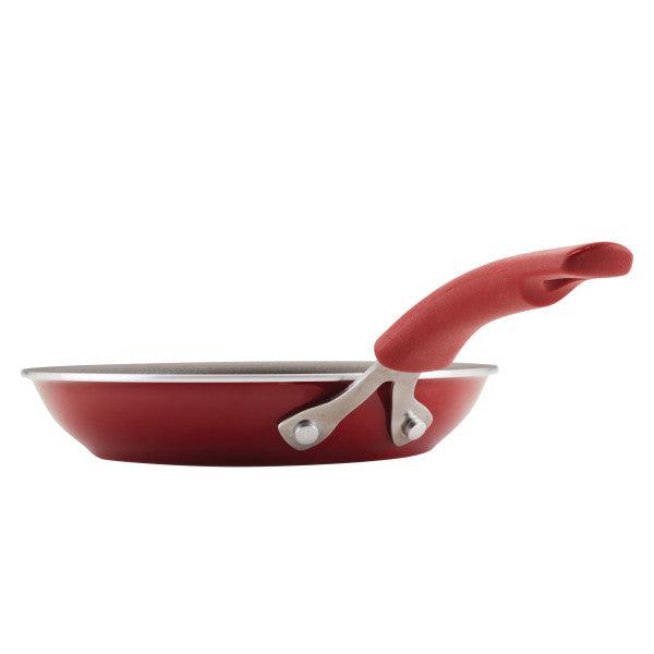 The high-performance Cook + Create Nonstick Frying Pan in red features a curved handle and is crafted from thicker gauge aluminum, offering an elegant side view.