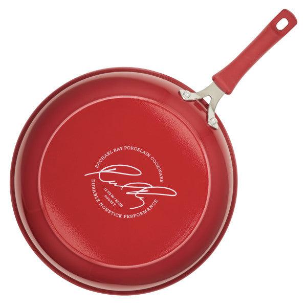 Introducing the Cook + Create Nonstick Frying Pan, a high-performance cooking essential crafted from thicker gauge aluminum, complete with a signature on the base and a coordinating red handle.