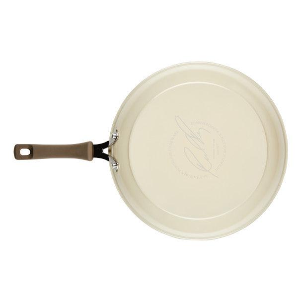 Cook + Create nonstick frying pan in cream with a brown handle, made from thicker gauge aluminum, viewed from above for optimal cooking performance.