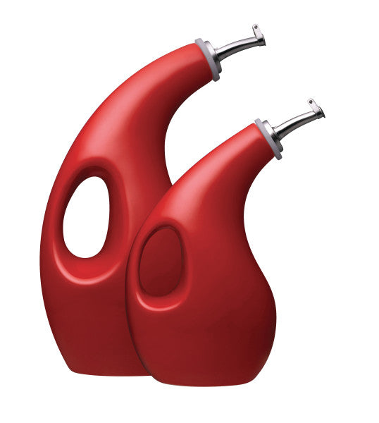 Two red, curvy oil dispensers with handles and metal spouts.