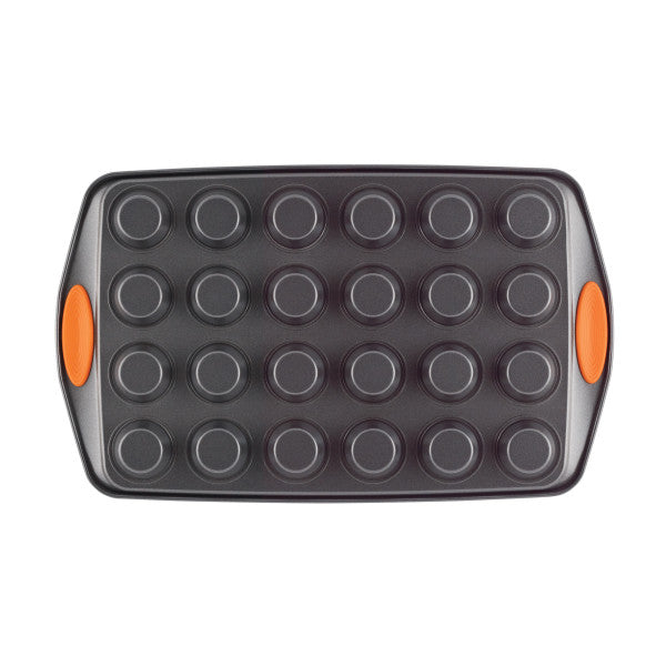 The 24-Cup Nonstick Mini Muffin Pan includes vibrant orange silicone handles and is oven-safe, offering a seamless nonstick baking experience.