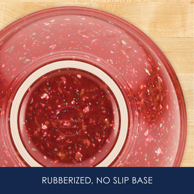 Red bowl with rubberized, non-slip base on a wooden surface.