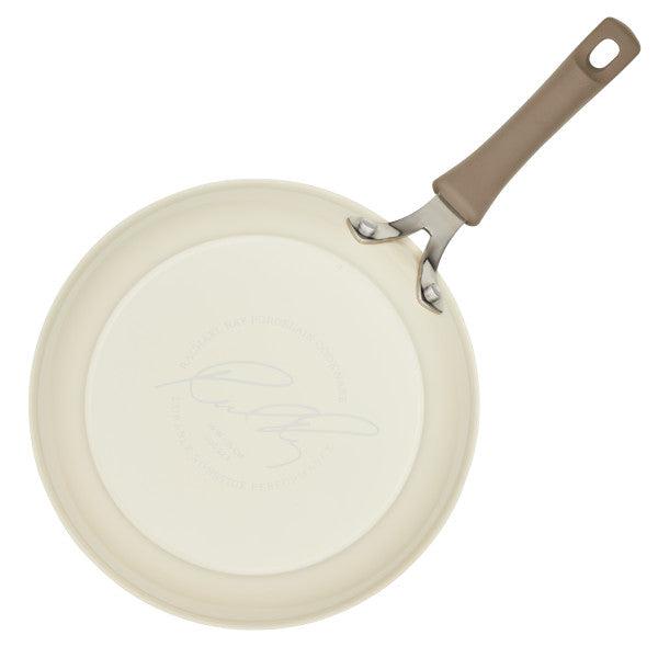 Introducing the Cook + Create Nonstick Frying Pan, designed with a thicker gauge aluminum body and adorned with a beige handle. The base features elegant embossed writing, ensuring both high performance and style in your kitchen.