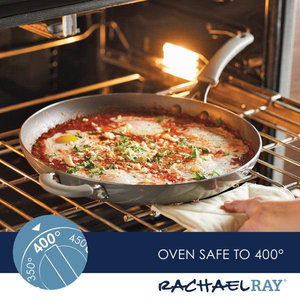 A person skillfully handles the Cook + Create Nonstick Frying Pans in the oven, where food is baking to perfection. The high-performance, thicker gauge aluminum of these pans ensures even heat distribution for flawless results every time.