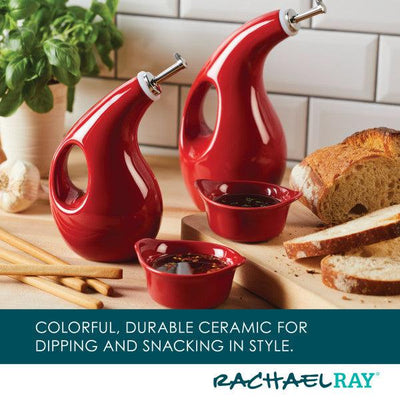Red ceramic oil dispensers and bowls beside bread and breadsticks.