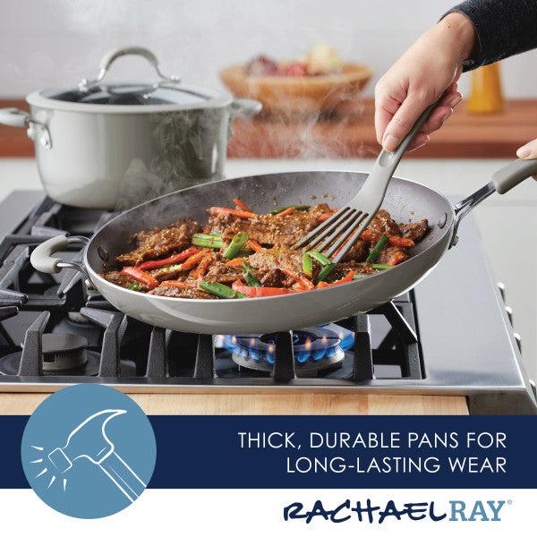 On the stove, a Cook + Create Nonstick Frying Pan delivers high performance as it sizzles with food, while a pot waits in the background. Made from thicker gauge aluminum, this kitchen essential guarantees even cooking every time.