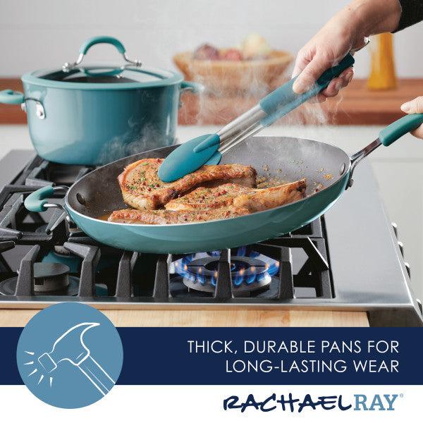 A person expertly cooks pork chops in the Cook + Create Nonstick Frying Pan on the stove, enjoying the even heat distribution provided by its thicker gauge aluminum construction.