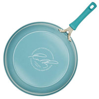 The Cook + Create Nonstick Frying Pan in teal is crafted from high-performance, thicker gauge aluminum and features a signature on its bottom.
