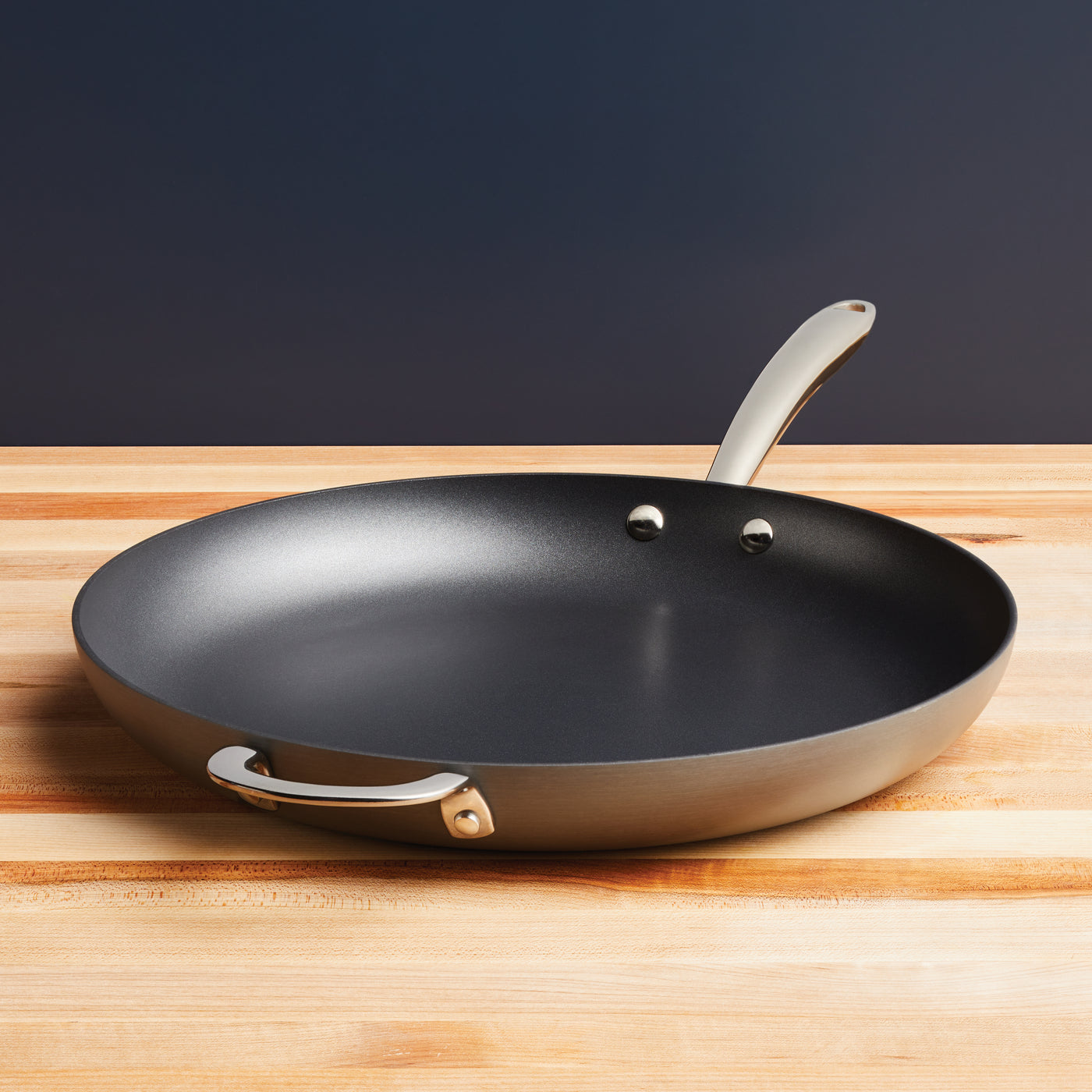 14-Inch Pro Hard Anodized Nonstick Frying Pan on wooden surface with handles.