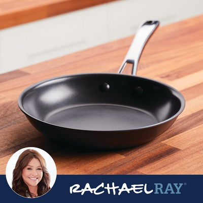 Nonstick frying pan with a black handle on a wooden kitchen countertop.