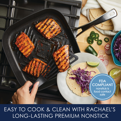 Grilling salmon in a pan, with tortillas and cabbage on the side.