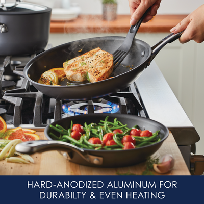 Cooking salmon and vegetables on a stove with hard-anodized aluminum pans.