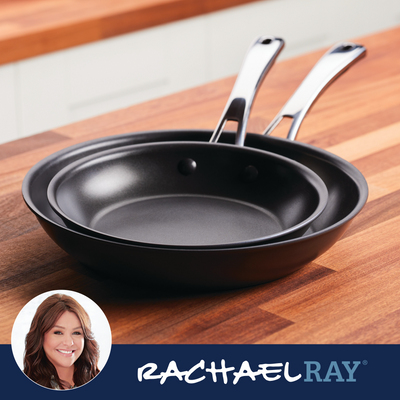 Two black frying pans on a wooden countertop.