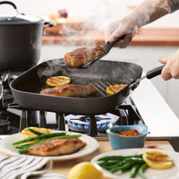 Using the 11-Inch Cook + Create Hard Anodized Nonstick Deep Grill Pan to cook chicken breasts and lemon slices ensures even heating and exceptional scratch resistance.