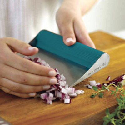 Person chopping onions with a teal-handled knife on a wooden board.