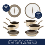 Two silicone-rimmed glass lids beside a beige cookware set with pans.