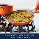 A frittata in an orange pan on a gas stove burner.