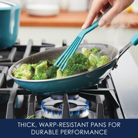 Cooking broccoli in a blue pan on a gas stove.