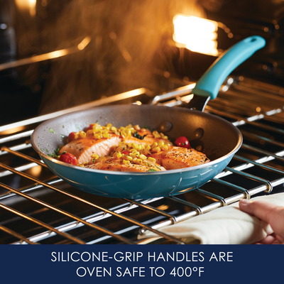 Salmon cooking in a blue pan with silicone-grip handle in an oven.