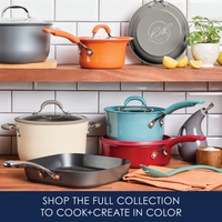 Colorful cookware displayed on wooden shelves in a kitchen setting.