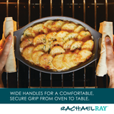 Person holding a dish of baked potato slices in an oven.