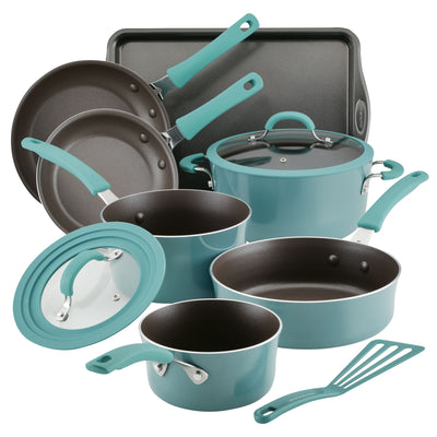 Set of teal cookware with pots, pans, lids, baking tray, and spatula.