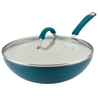 Teal frying pan with a glass lid and dual riveted handle.
