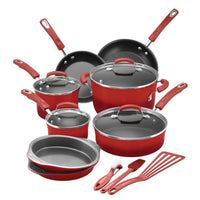 Red cookware set with pots, pans, and utensils on white background.