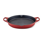 The 14-Inch NITRO Cast Iron Skillet is a vibrant red piece featuring two sturdy handles. Oven safe and induction ready, it offers style and versatility to your kitchen, set against a crisp white background.