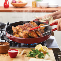 A person cooks seasoned chicken with lemon slices in a 14-Inch NITRO Cast Iron Skillet, perfectly designed for an induction-ready stove.