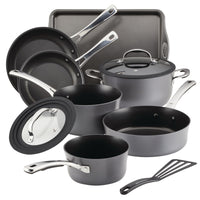 A black nonstick cookware set with pans, pots, lids, a tray, and a spatula.