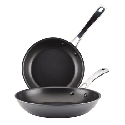 Two black frying pans with silver handles, one stacked on the other.