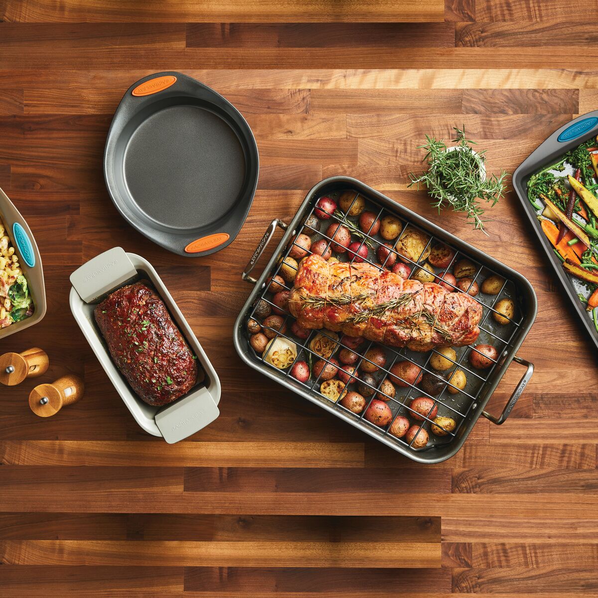 Roast and veggies on a wooden table with other cookware and ingredients.