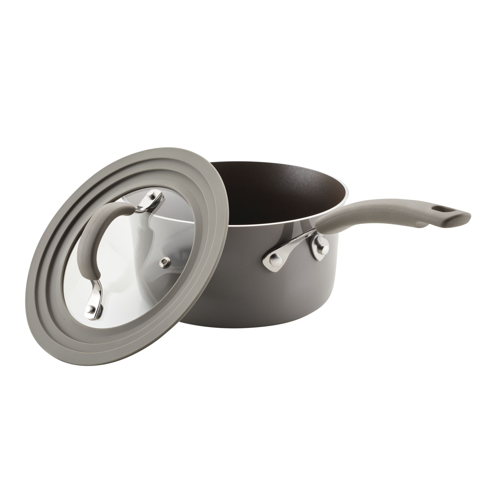 Partially open gray saucepan from the 6-Piece Cook + Create Nonstick Cookware Set, made from durable aluminum with a glass lid, on a white background.