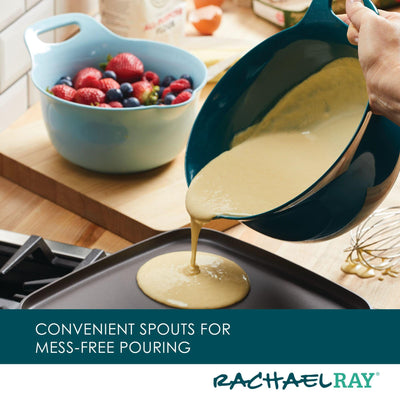 Pouring pancake batter onto a griddle from a bowl with a spout.