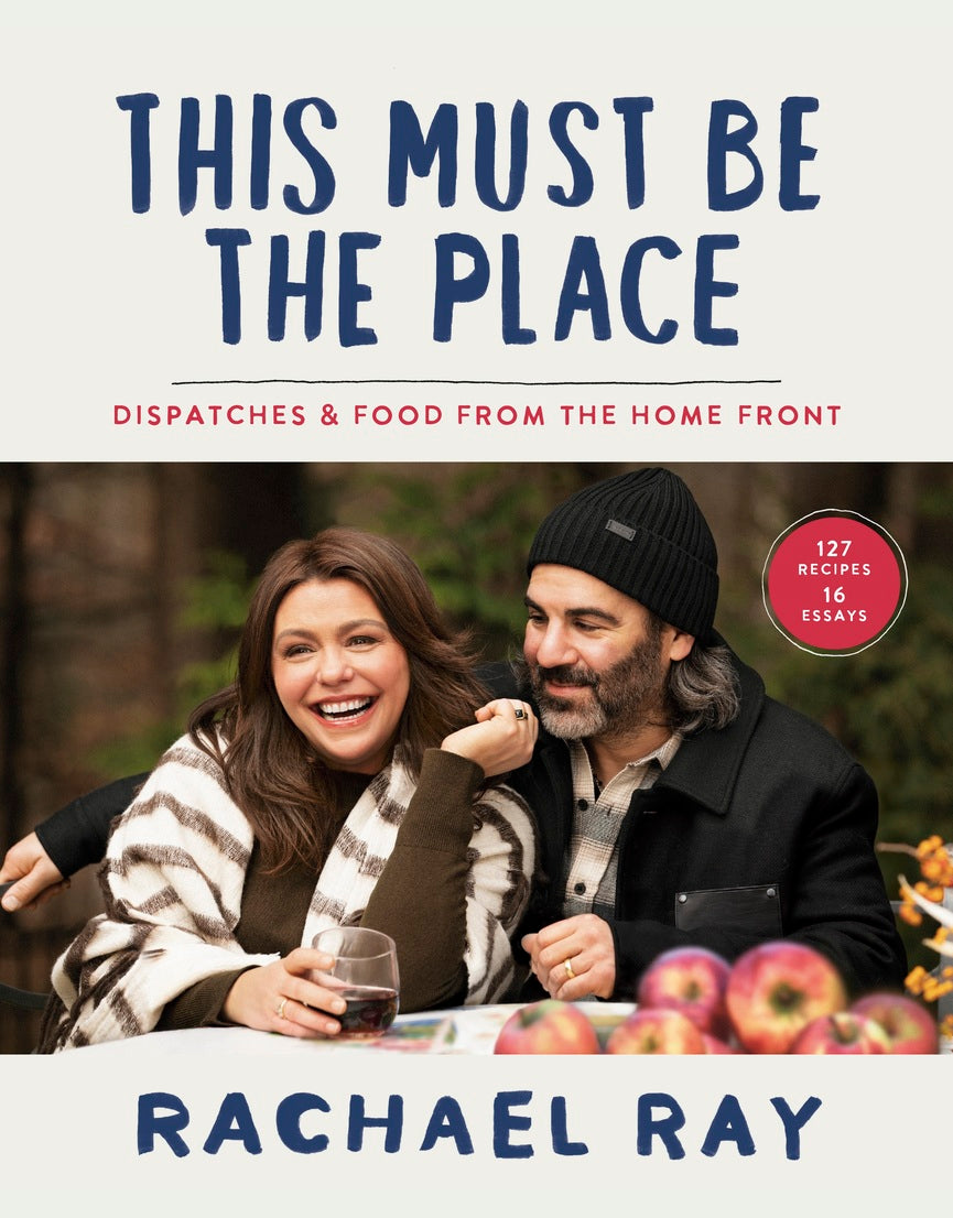 Two people sitting outdoors with a book titled "This Must Be The Place.