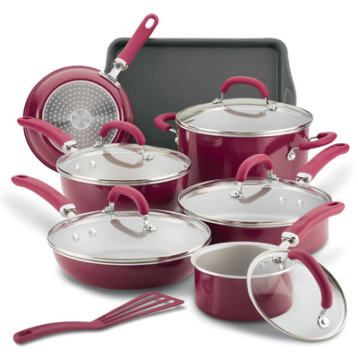 Red cookware set with pots, pans, lids, and a baking tray on display.